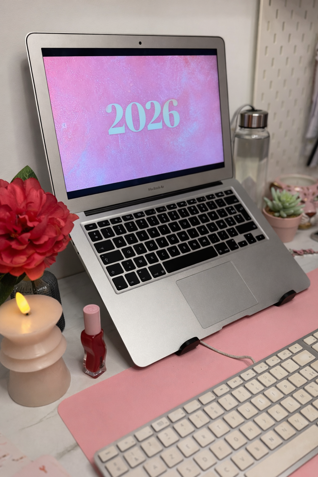 Bureau de travail avec ordinateur, cahier et bougie, communication digitale.